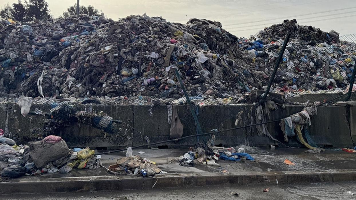 İzmir Buca'da şantiyedeki çöpler yağmur sularıyla yola dağıldı